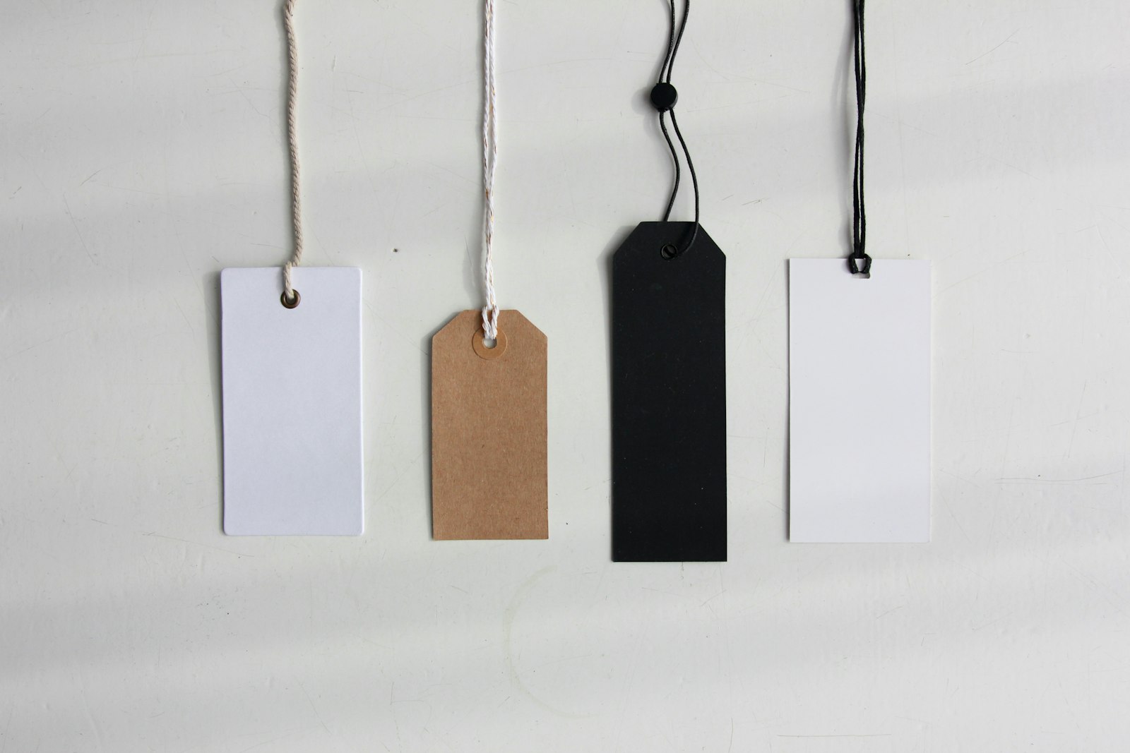 Four paper price tags on a plain background